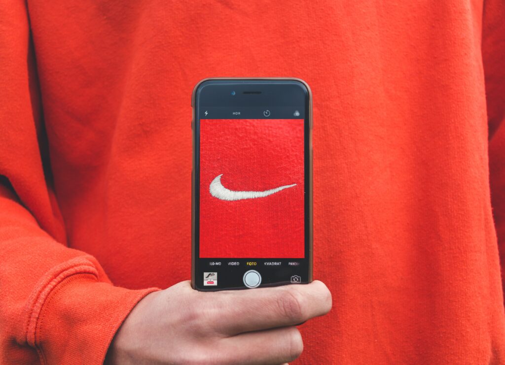image shows red sweatshirt with a smart phone hovering over a logo.
